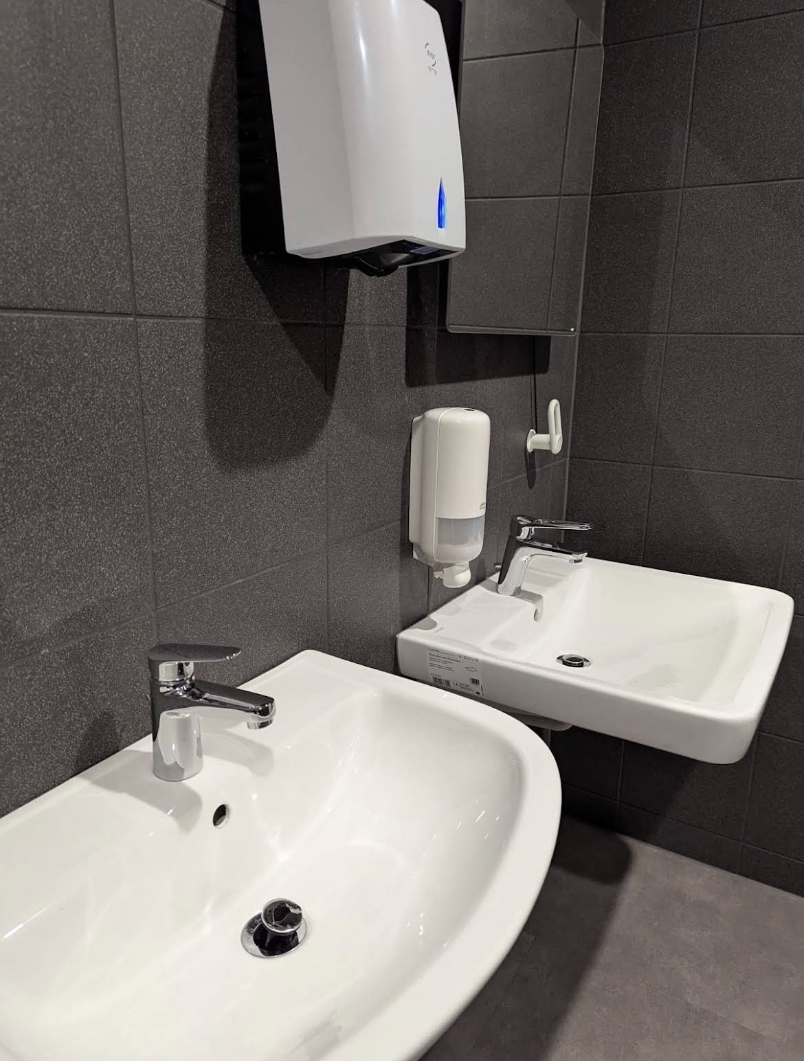 Referenz: Gereinigter Sanitärbereich mit polierten Waschbecken und Armaturen